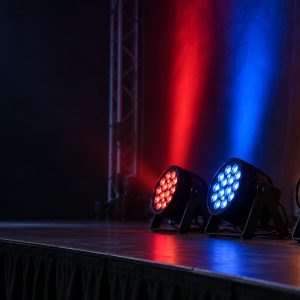 LED PAR stage lights casting red, blue, and amber washes across a stage.
