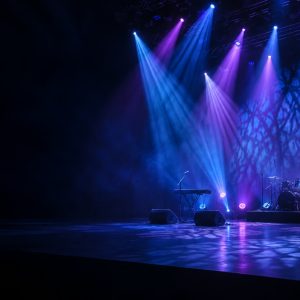 Stage effects lighting casting blue and violet beams and patterns across an empty venue.