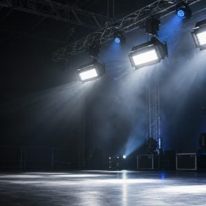 Professional strobe lights mounted on a truss above an empty stage.